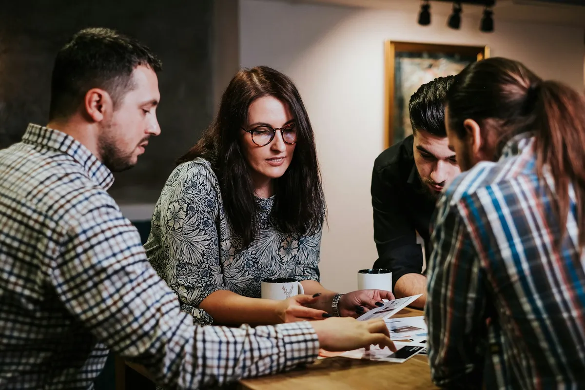 Equipe em reunião de trabalho discutindo bem-estar e saúde mental no escritório